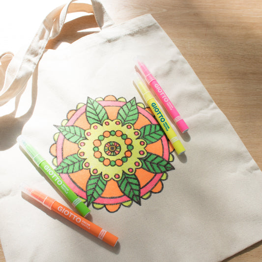 Canvas tote bag with mandala design and Giotto markers on a wooden surface