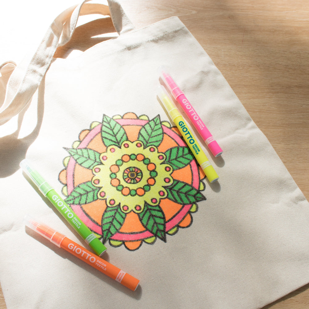 Canvas tote bag with mandala design and Giotto markers on a wooden surface