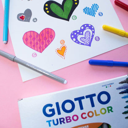 Colorful heart drawings on paper with Giotto Turbo Color markers on a pink background